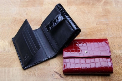 <h5>1281 73</h5><p>Women´s wallet in black and red.	This wallet has 13 credit card slots, two net compartments, 6 slip pockets and a double billfold and a double coin compartment. Size : 12,5 x 10,5 cm																																</p>